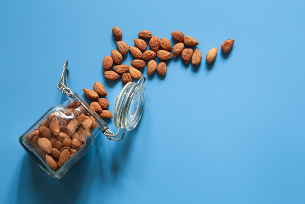 scattered almond nuts blue background flat lay