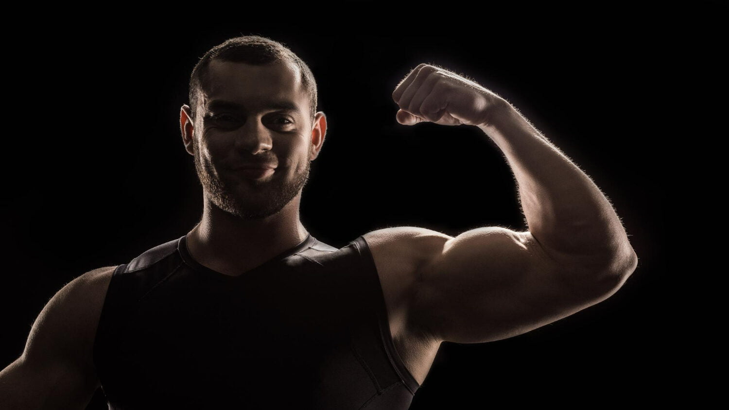 Young Caucasian Bodybuilder Flexing Biceps Looking Camera