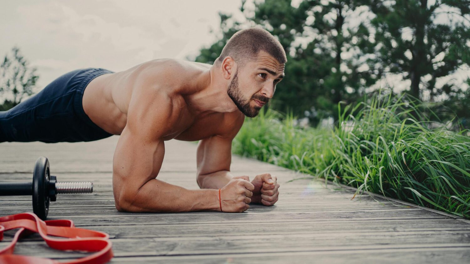 Muscular Bodybuilder Stands Plank Pose Demonstrates Endurance Has Strong Biceps Poses Outdoor Has Athletic Workout Poses Outdoor Keeps Good Physical Shape Man Doing Push Ups Concentared Forward