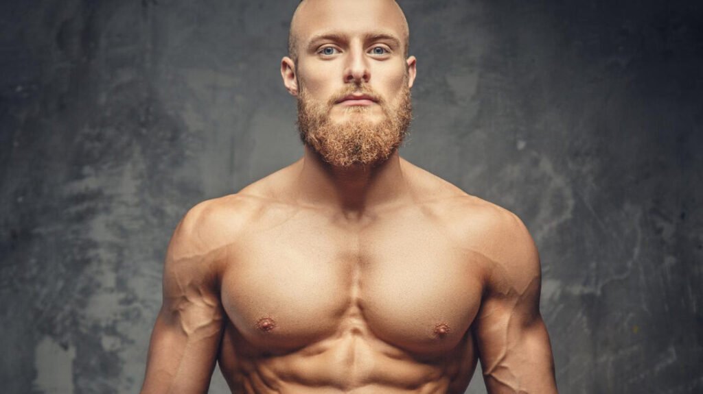 Shirtless Muscular Bearded Man Red Pants Posing Studio Grey Background